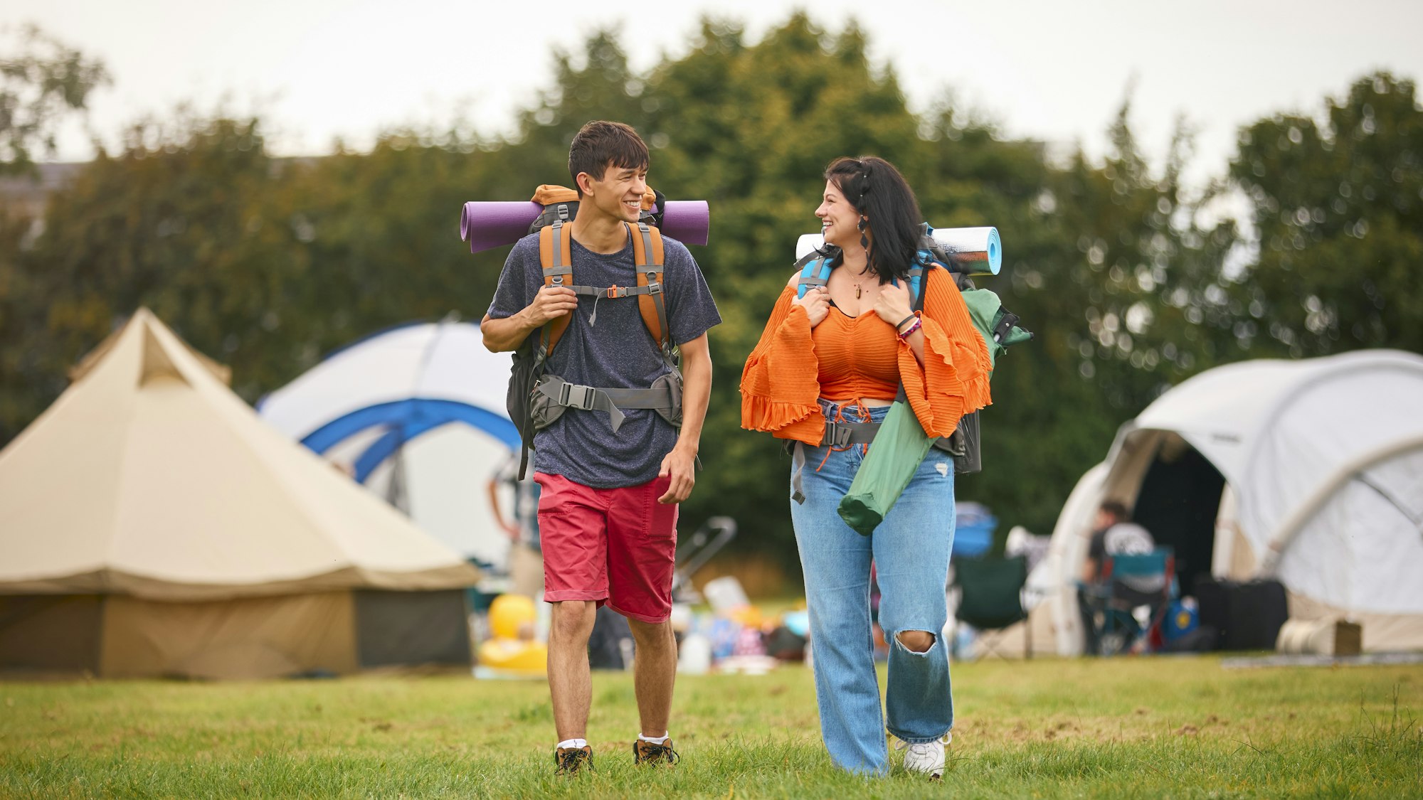 Young Couple Meeting At Summer Music Festival With Camping Equipment